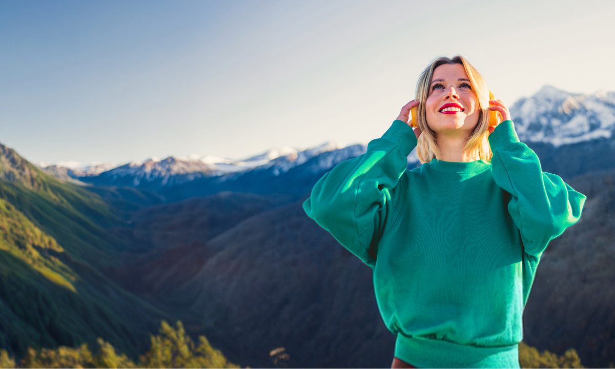 hero-img-banner Woman enjoying mountain scenery with headphones